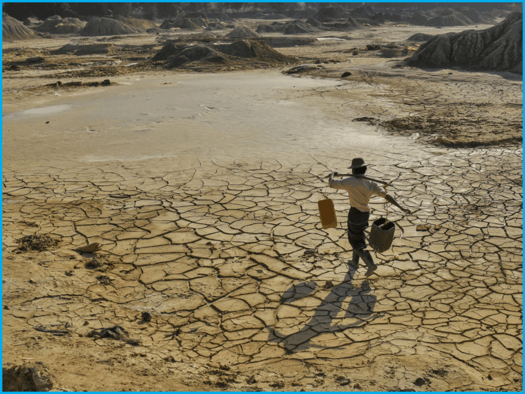 homme allant chercher de l'eau avec 2 bidons dans un lac asséché
