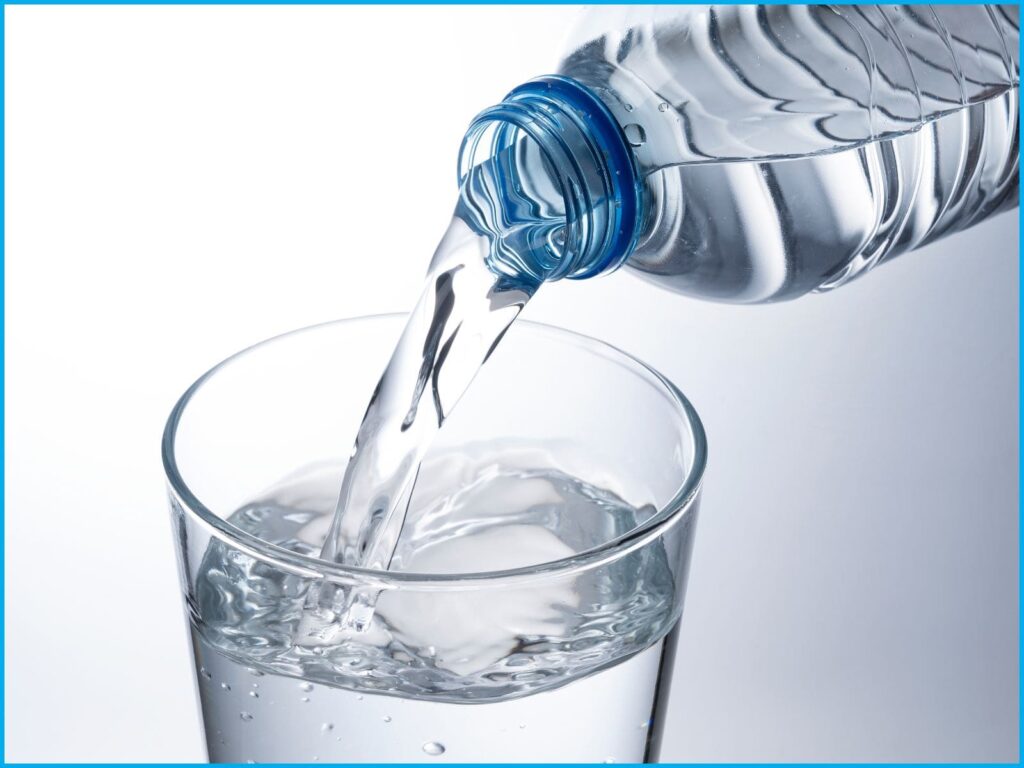 bouteille en plastique versant de l'eau dans un verre